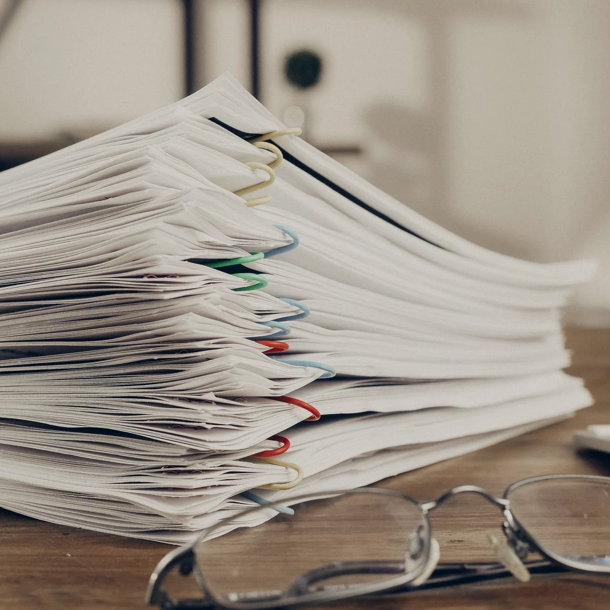 A stack of clipped reports on a desk.